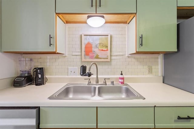 kitchen featuring sink, decorative backsplash, and green cabinets