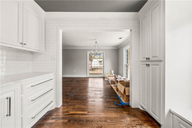 dining space with dark hardwood / wood-style floors, an inviting chandelier, and ornamental molding