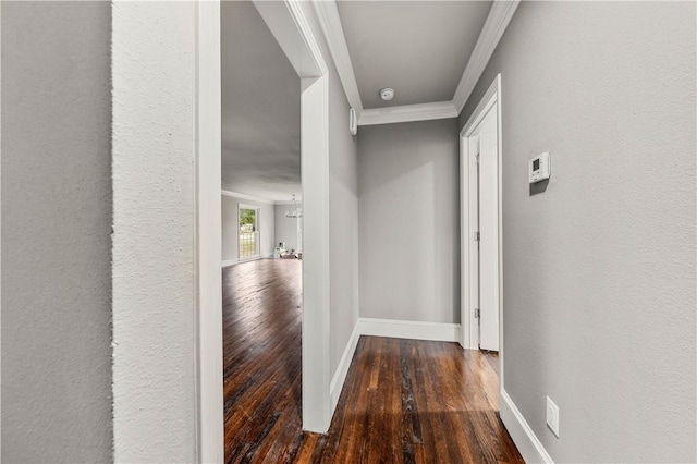 hall with dark hardwood / wood-style floors, an inviting chandelier, and crown molding