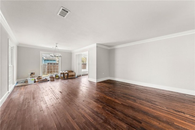 unfurnished living room with crown molding, dark wood-type flooring, and an inviting chandelier