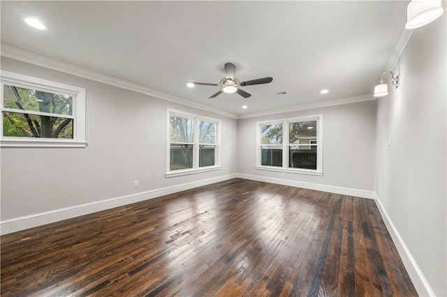 spare room with dark hardwood / wood-style floors, a wealth of natural light, and ornamental molding