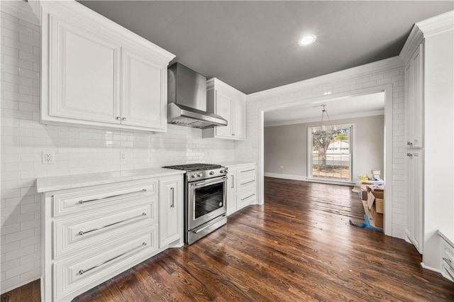 kitchen featuring dark wood-type flooring, high end stainless steel range oven, white cabinetry, and wall chimney exhaust hood