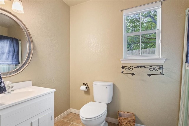 bathroom with tile patterned flooring, vanity, and toilet