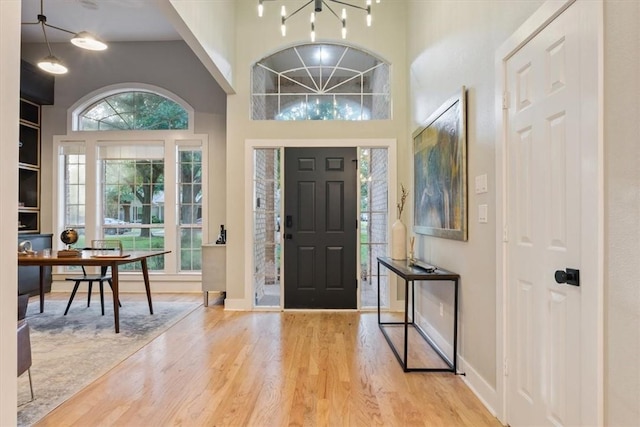 entrance foyer featuring a notable chandelier, light hardwood / wood-style floors, and a high ceiling