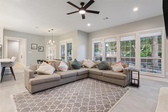 living room with plenty of natural light, light tile patterned flooring, ceiling fan with notable chandelier, and french doors