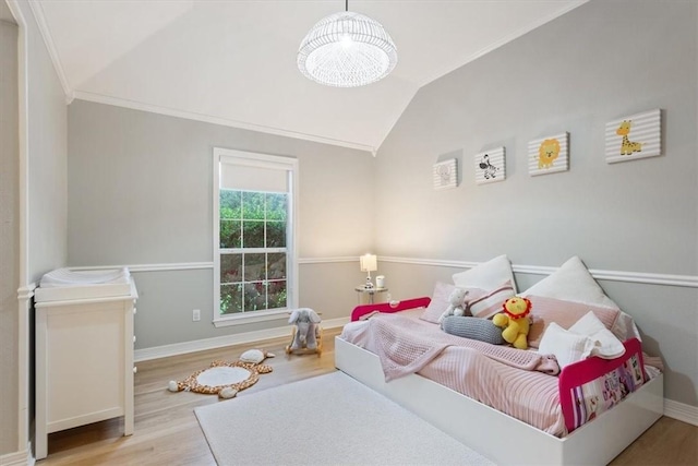 bedroom with light hardwood / wood-style flooring, vaulted ceiling, and crown molding