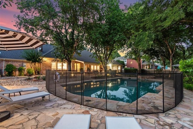 pool at dusk with a patio