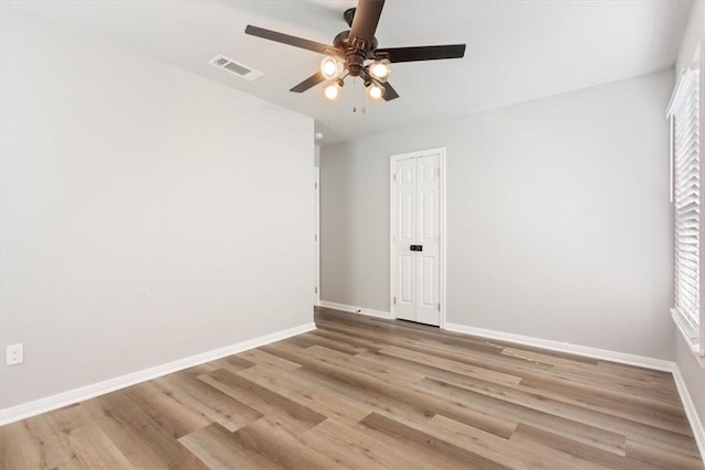 empty room with light hardwood / wood-style floors, ceiling fan, and a wealth of natural light