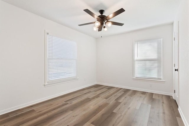 empty room with ceiling fan and light hardwood / wood-style flooring