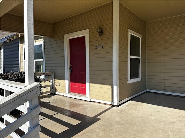 view of exterior entry with a patio area