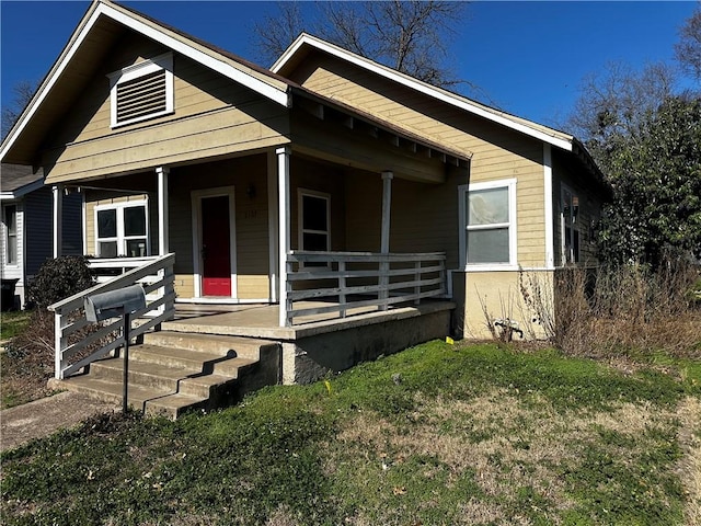 bungalow with a front yard and covered porch