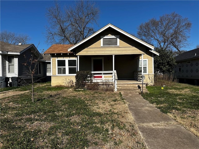 bungalow-style house with a front yard and covered porch