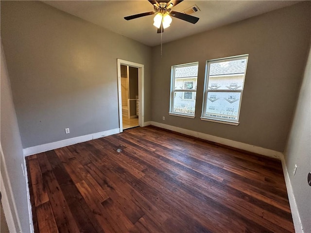 spare room featuring baseboards, visible vents, dark wood finished floors, and a ceiling fan