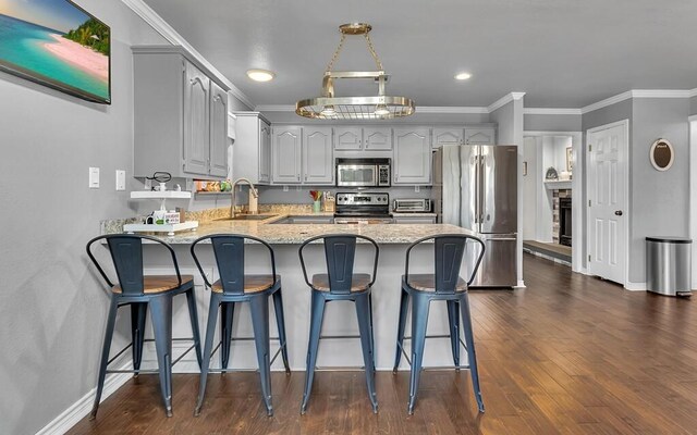 kitchen featuring appliances with stainless steel finishes, crown molding, dark wood-type flooring, sink, and gray cabinets