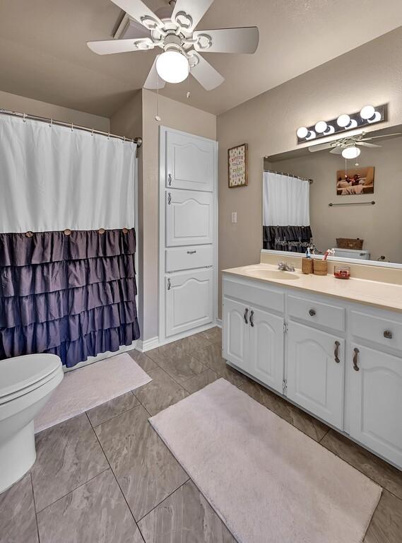 bathroom featuring ceiling fan, vanity, and toilet