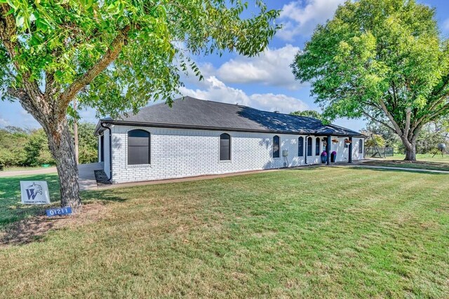 rear view of property featuring a yard