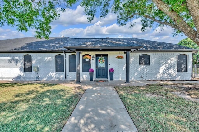 ranch-style house with a front lawn and covered porch