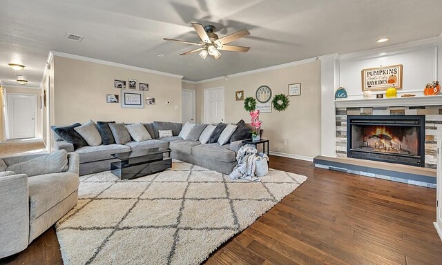 living room featuring hardwood / wood-style flooring, ceiling fan, crown molding, and a fireplace