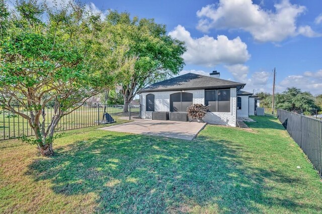 rear view of house featuring a yard and a patio