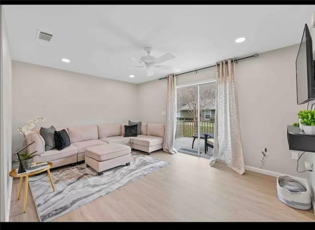 living area with ceiling fan, visible vents, baseboards, and wood finished floors