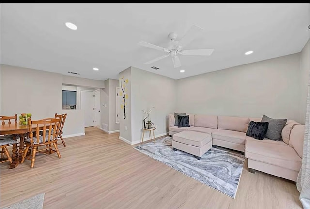 living room featuring light wood-type flooring, visible vents, a ceiling fan, recessed lighting, and baseboards