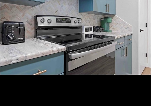 kitchen with backsplash, blue cabinetry, stainless steel electric range oven, and light countertops