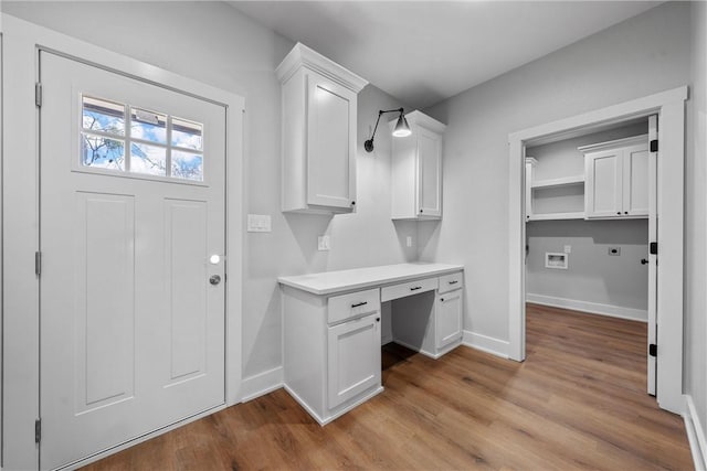 interior space with wood finished floors, built in study area, and baseboards