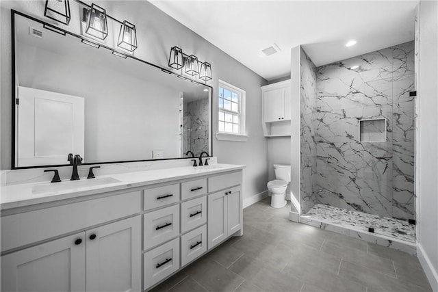 bathroom featuring toilet, a marble finish shower, a sink, and visible vents