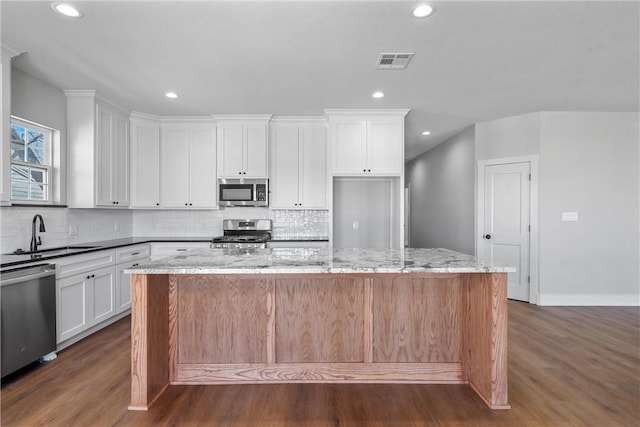 kitchen featuring white cabinetry, visible vents, stainless steel appliances, and a sink