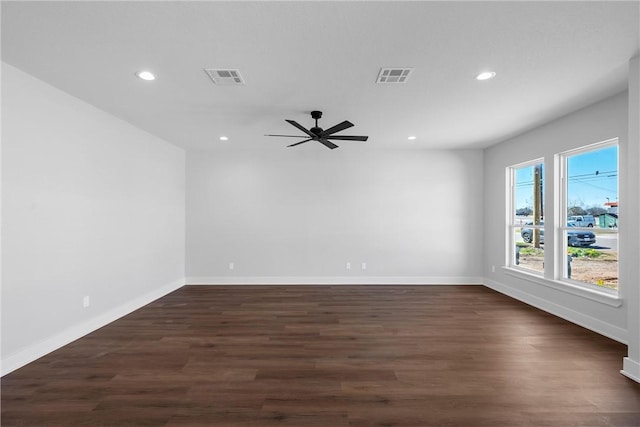 spare room with dark wood-style floors, baseboards, visible vents, and recessed lighting