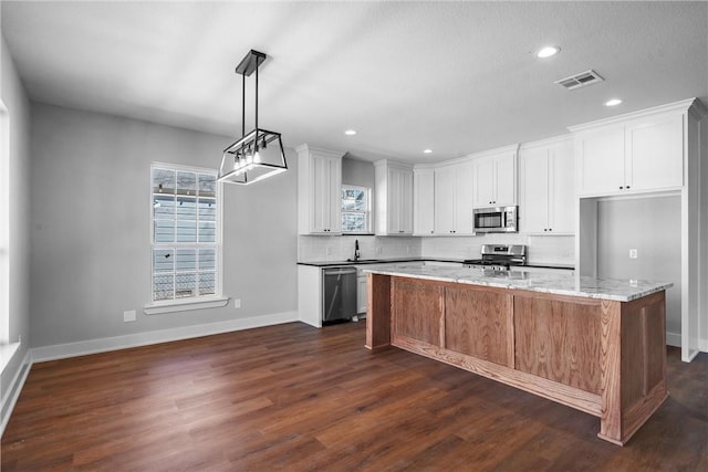 kitchen featuring dark wood-style floors, stainless steel appliances, visible vents, decorative backsplash, and white cabinets