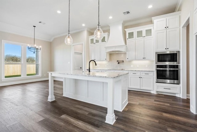 kitchen featuring white cabinetry, stainless steel appliances, and custom range hood