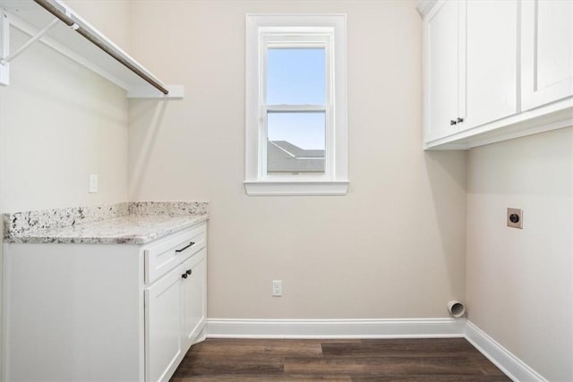 laundry room with cabinets, electric dryer hookup, and dark wood-type flooring