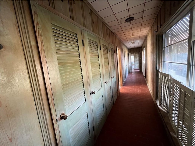 corridor featuring wooden walls