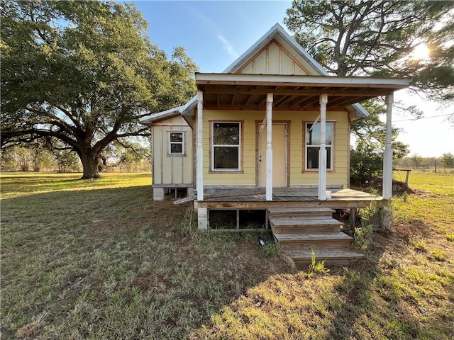 bungalow featuring covered porch and a front lawn