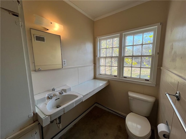 bathroom with toilet, tile walls, and ornamental molding