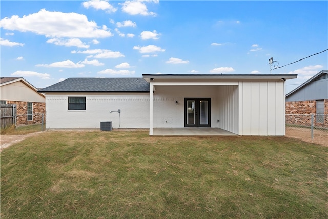 back of house featuring a yard, central AC unit, and a patio area