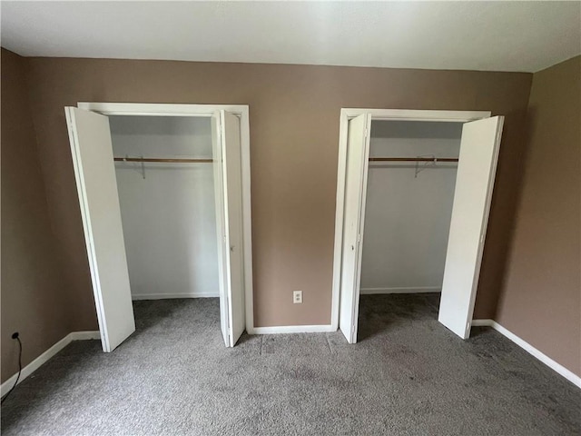 unfurnished bedroom featuring multiple closets and carpet