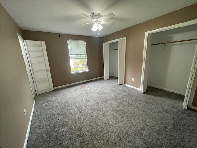 unfurnished bedroom with ceiling fan, multiple closets, and carpet flooring