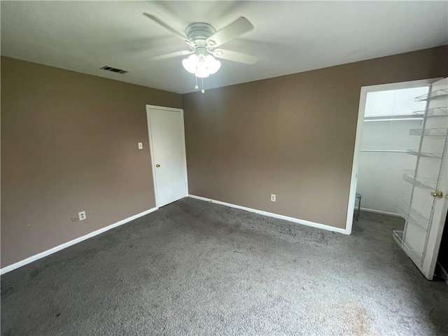 interior space with ceiling fan and dark colored carpet