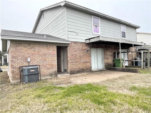 back of property with a patio area, a lawn, and central AC