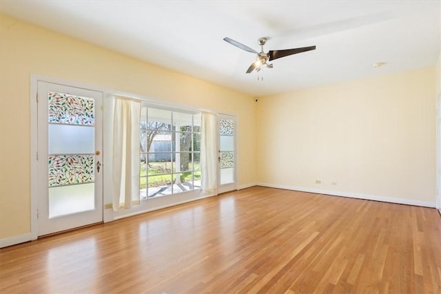 unfurnished room featuring baseboards, light wood finished floors, and ceiling fan