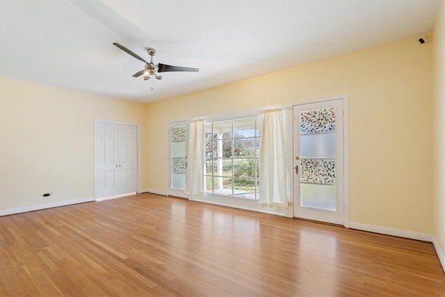 empty room with wood finished floors, baseboards, and ceiling fan