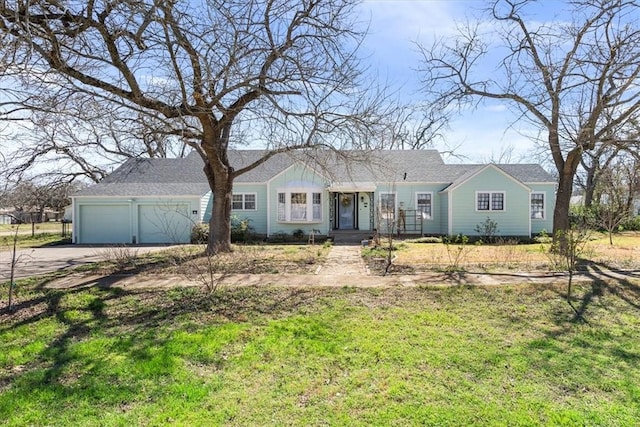 ranch-style house featuring an attached garage, concrete driveway, and a front yard