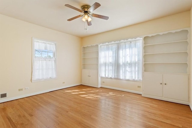 unfurnished room featuring visible vents, wood finished floors, baseboards, and ceiling fan