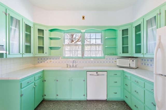 kitchen featuring backsplash, open shelves, glass insert cabinets, white appliances, and a sink