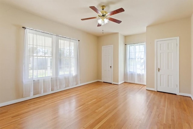 unfurnished room with light wood-type flooring, baseboards, and a ceiling fan