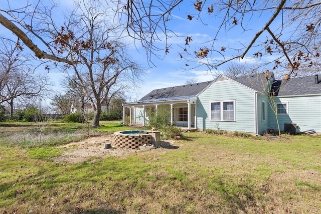 back of property with a yard and a porch