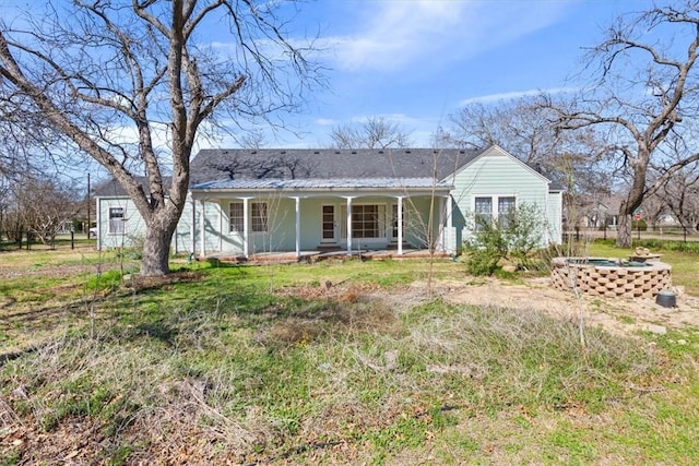 rear view of house featuring a porch and metal roof