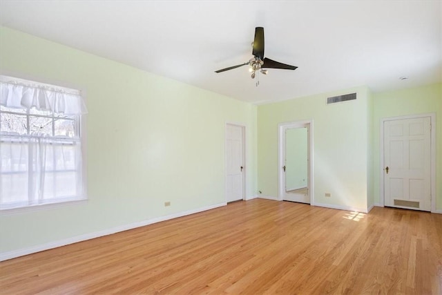 unfurnished room with light wood-type flooring, visible vents, baseboards, and a ceiling fan